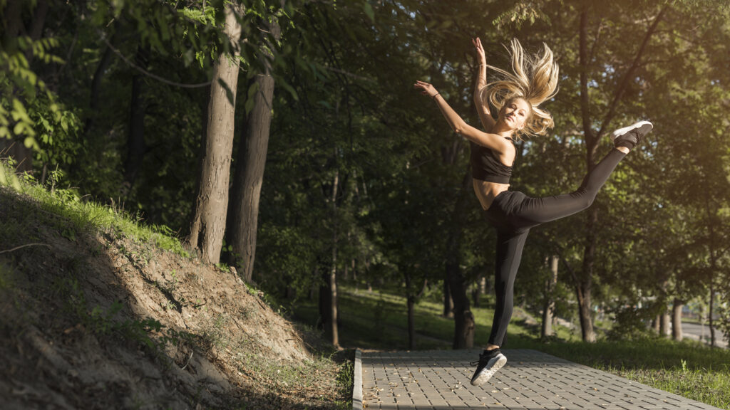 women mid-jump in a yoga pose