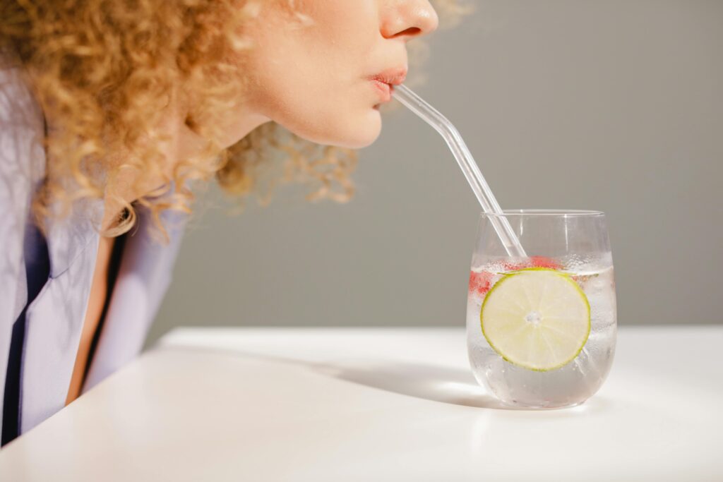 Person drinking warm lemon water to start the day and reduce bloating